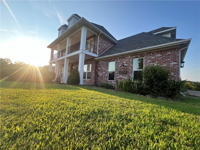 view of front of home with a front lawn and a balcony