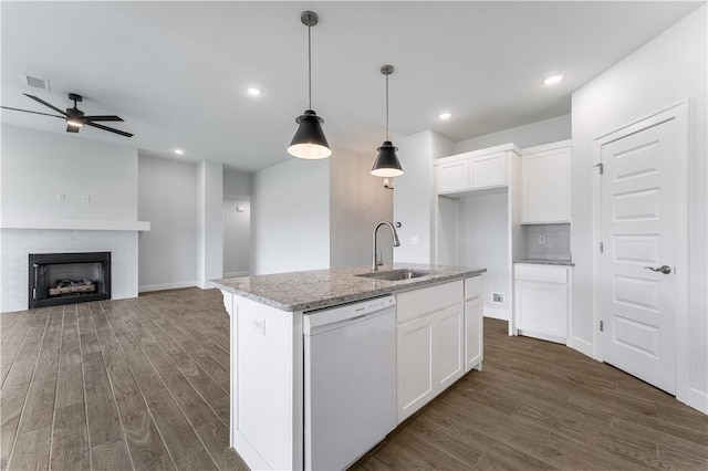 kitchen with a sink, white cabinets, light stone countertops, dishwasher, and an island with sink