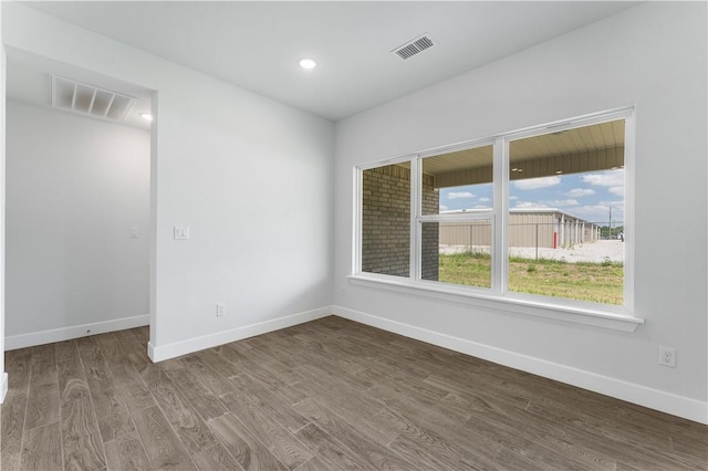 empty room with visible vents, baseboards, and wood finished floors