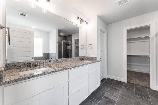 full bathroom featuring a sink, a walk in closet, and visible vents