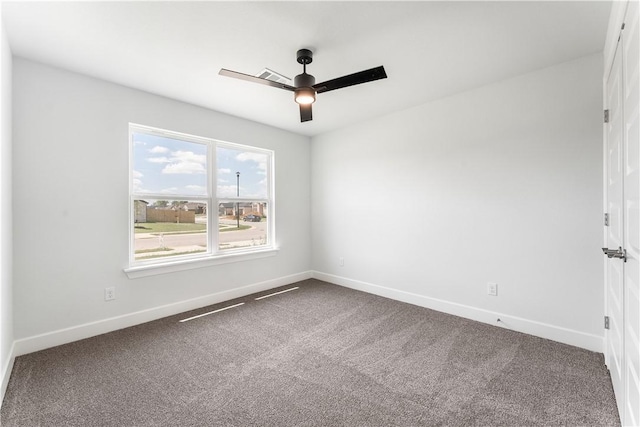 carpeted empty room with ceiling fan and baseboards