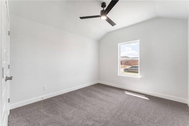 empty room with carpet floors, vaulted ceiling, baseboards, and ceiling fan