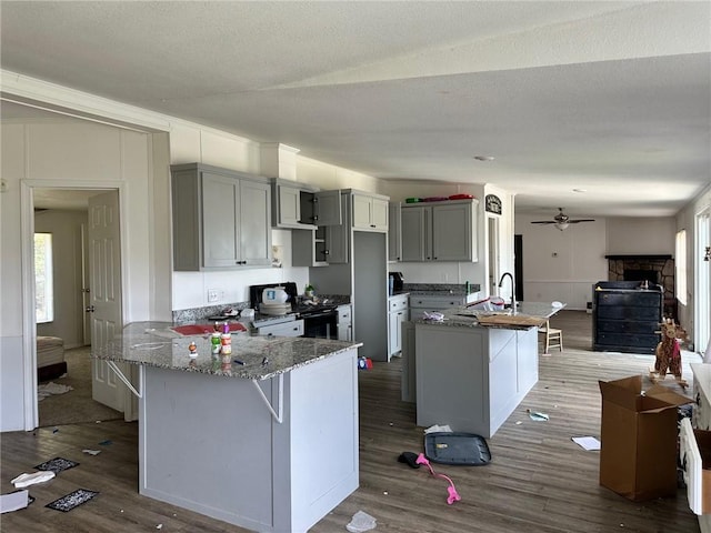 11121 Wolf Track Rd, Summers, AR 72769 - kitchen with dark wood-style floors, stone counters, ceiling fan, and a peninsula