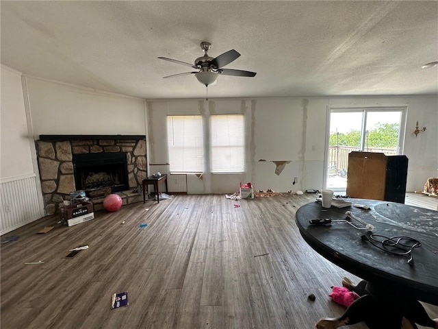 11121 Wolf Track Rd, Summers, AR 72769 - living area featuring ceiling fan, wood finished floors, a textured ceiling, and a fireplace