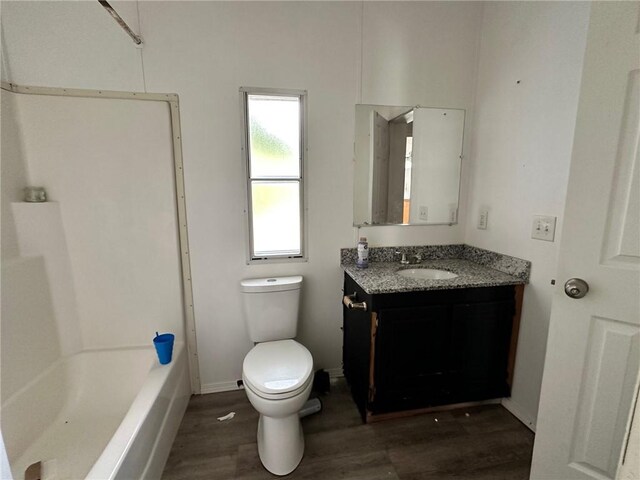 11121 Wolf Track Rd, Summers, AR 72769 - bathroom featuring wood finished floors, toilet, vanity, baseboards, and bathtub / shower combination