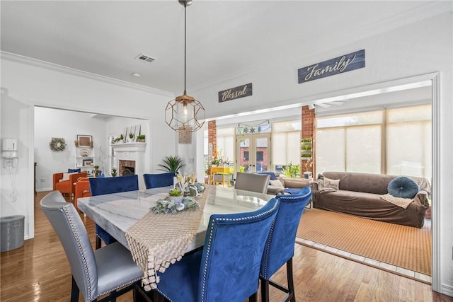 dining space featuring hardwood / wood-style floors, french doors, and crown molding