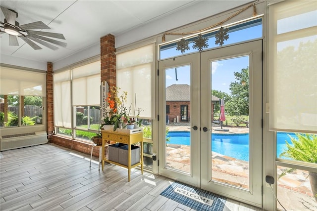 sunroom / solarium featuring french doors and ceiling fan