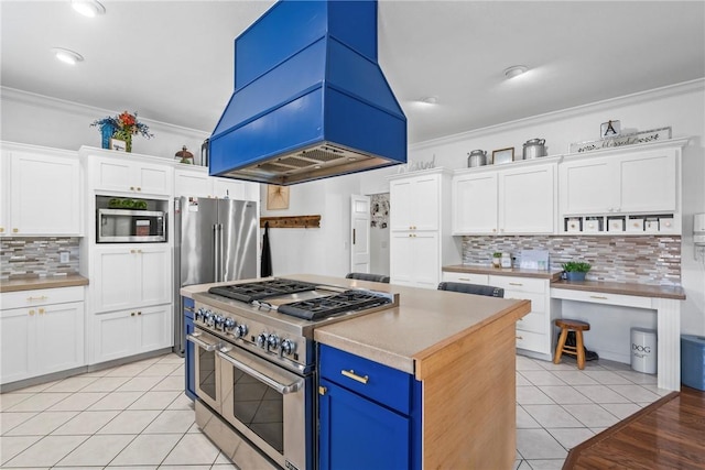 kitchen with high quality appliances, white cabinetry, and island exhaust hood