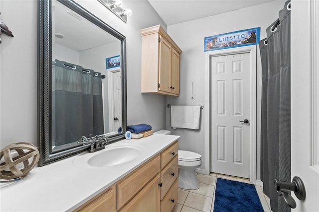 bathroom with tile patterned flooring, vanity, and toilet