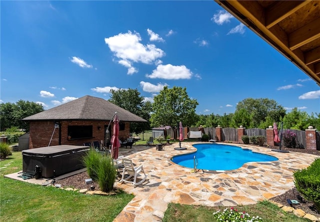 view of swimming pool featuring a hot tub and a patio area
