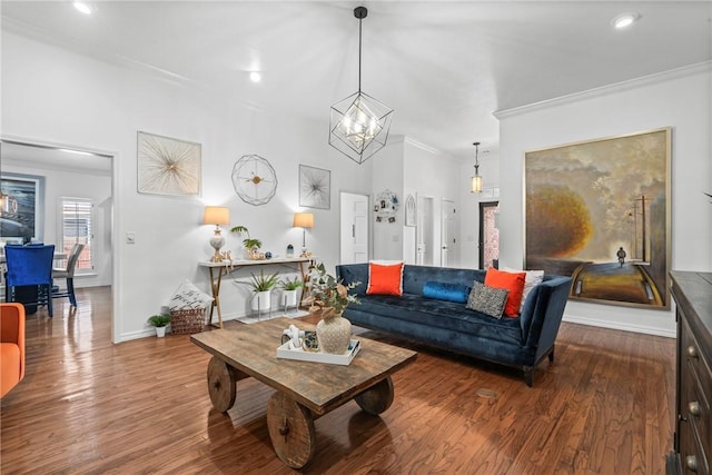 living room with hardwood / wood-style floors, crown molding, and an inviting chandelier