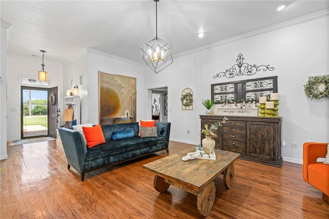 living room featuring a notable chandelier, ornamental molding, and wood-type flooring