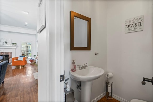 bathroom featuring hardwood / wood-style flooring and a brick fireplace