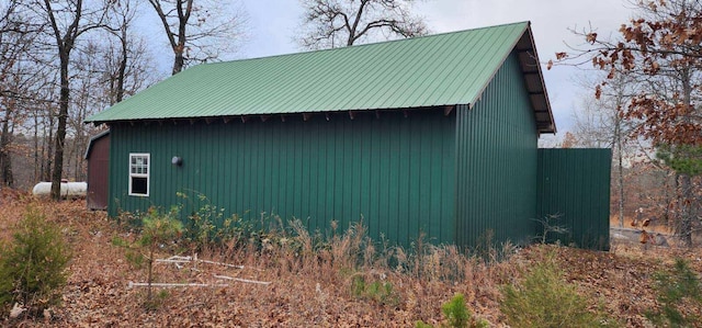 view of property exterior with metal roof and an outdoor structure