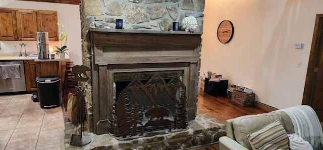 details with a stone fireplace and stainless steel dishwasher