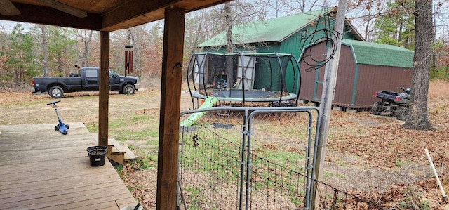 view of yard with a trampoline and a shed