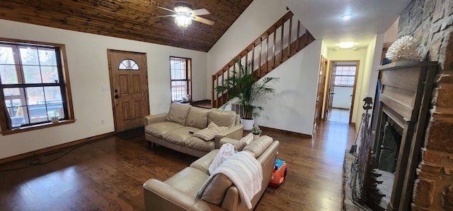 living room featuring ceiling fan, high vaulted ceiling, dark hardwood / wood-style floors, and a stone fireplace