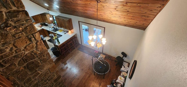 unfurnished living room with wood ceiling, wood finished floors, a textured wall, and lofted ceiling