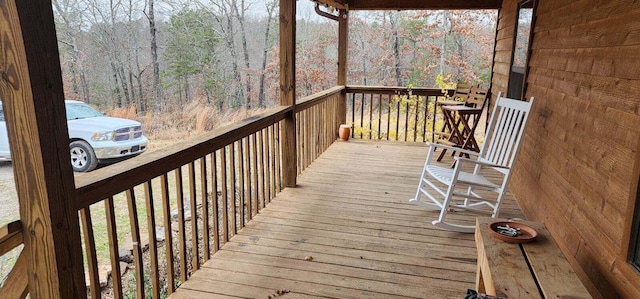 wooden terrace featuring a wooded view