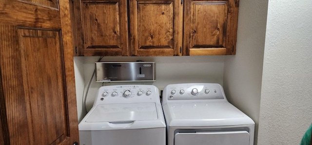 washroom featuring washer and clothes dryer and cabinets