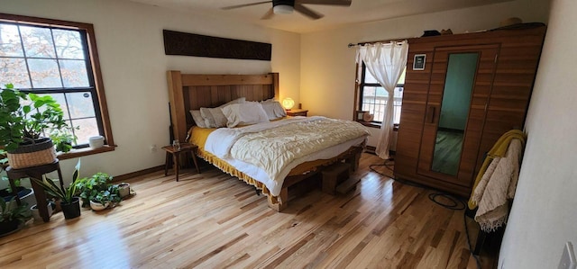 bedroom with light wood-type flooring, baseboards, and a ceiling fan