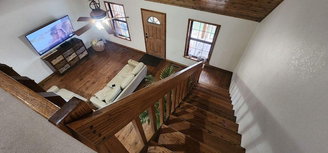 stairway with a ceiling fan, lofted ceiling, wood finished floors, and wood ceiling