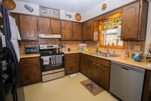 kitchen with appliances with stainless steel finishes, sink, and tasteful backsplash