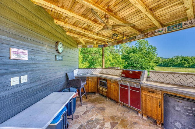 view of patio featuring area for grilling, ceiling fan, and exterior kitchen