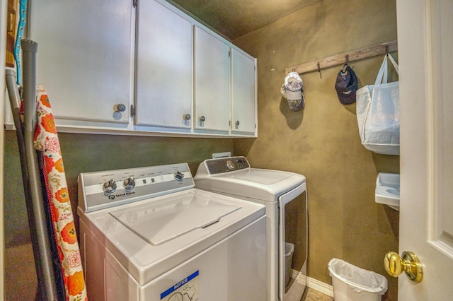 laundry room featuring washing machine and clothes dryer and cabinets