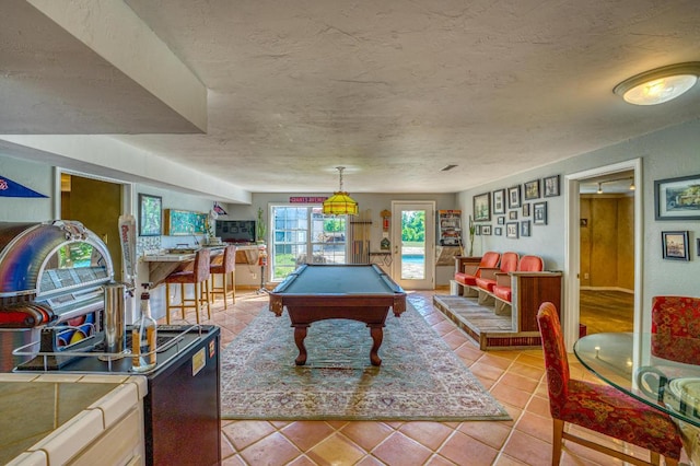 game room with light tile patterned floors, a textured ceiling, and billiards