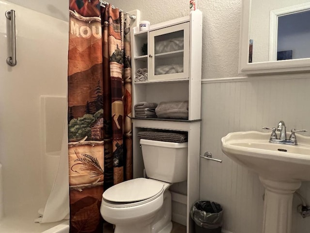 bathroom with toilet and a shower with shower curtain