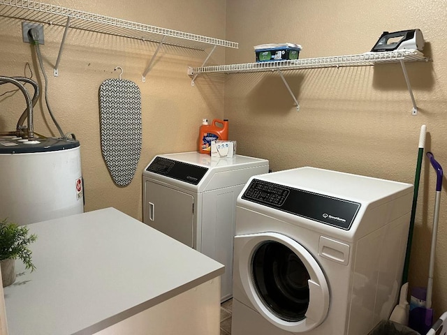 laundry area with water heater and washer and dryer