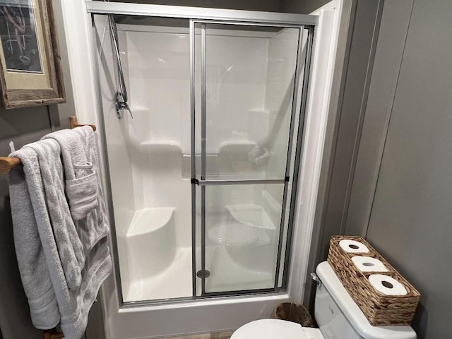 bathroom with combined bath / shower with glass door and toilet