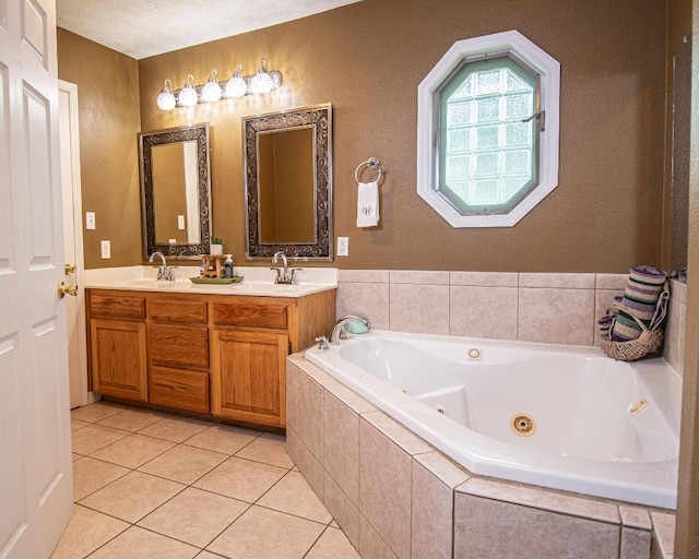 bathroom with tiled bath, vanity, tile patterned floors, and a textured ceiling