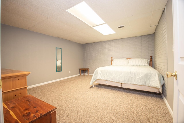 carpeted bedroom with brick wall