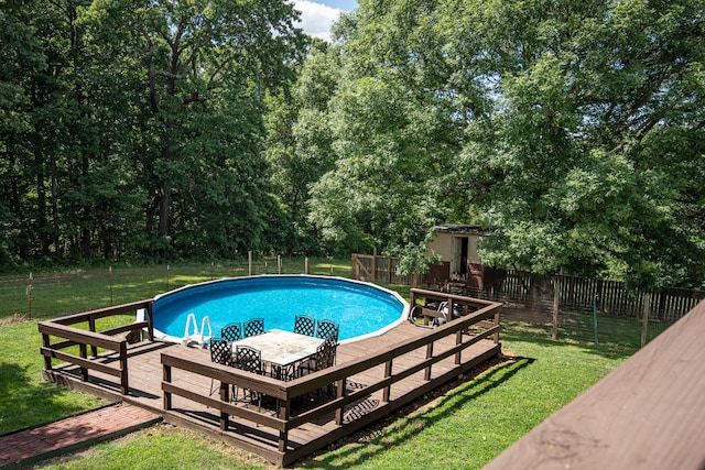 view of pool with a deck and a yard