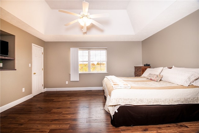 bedroom featuring ceiling fan, dark hardwood / wood-style floors, and a raised ceiling