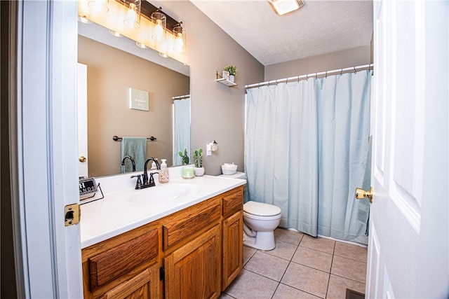 bathroom featuring toilet, tile patterned flooring, a textured ceiling, vanity, and walk in shower