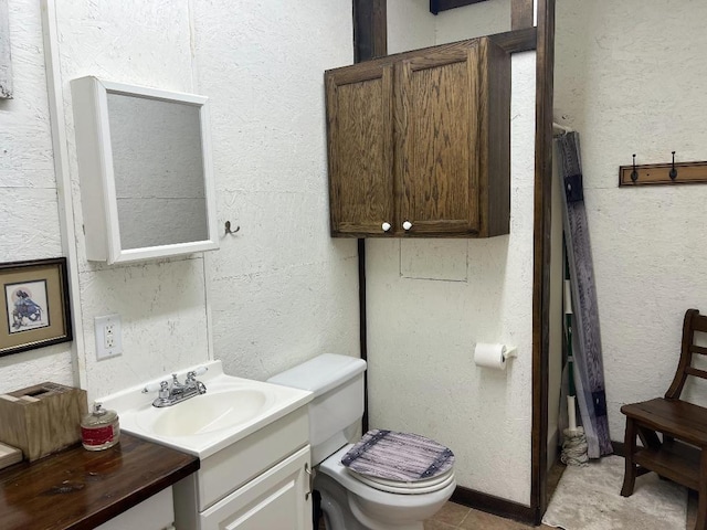 bathroom featuring vanity, tile patterned flooring, and toilet