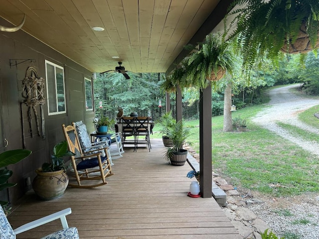 deck featuring ceiling fan and a lawn