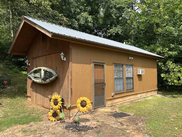 view of outbuilding with a yard and a wall unit AC