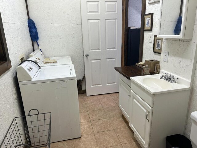 laundry room with washer and clothes dryer, light tile patterned floors, and sink