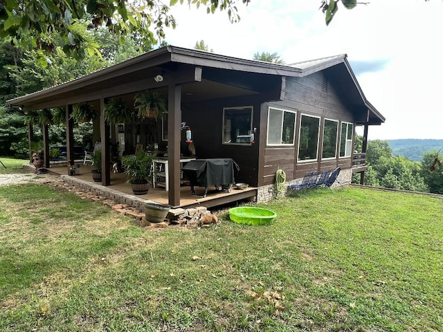 back of house featuring a yard and a patio area