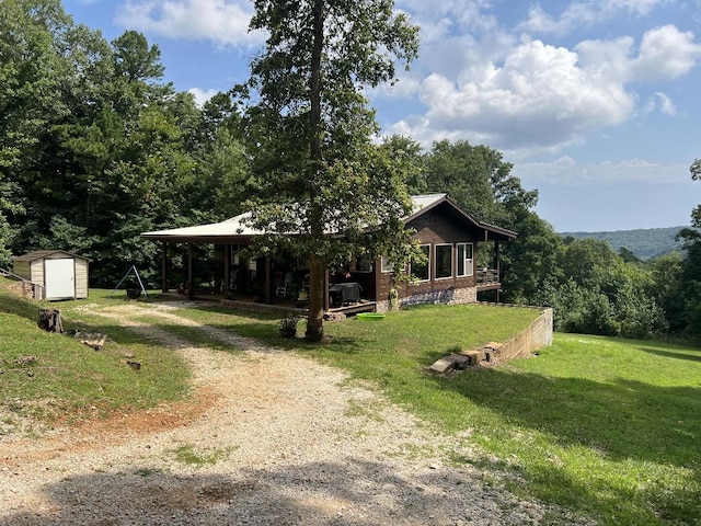 view of front of property featuring a storage shed and a front lawn