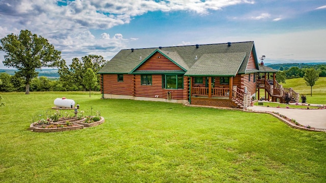 rear view of house featuring stairway, a lawn, and log siding