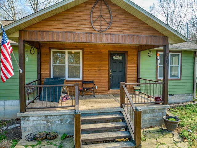 view of front facade with covered porch and a shingled roof