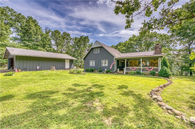 back of property featuring a lawn and covered porch