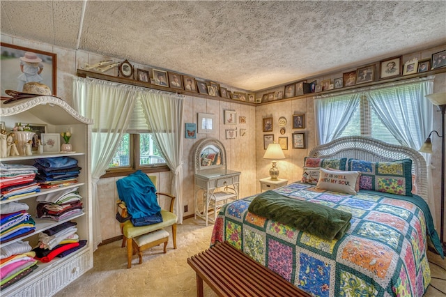 bedroom featuring a textured ceiling, carpet floors, and multiple windows