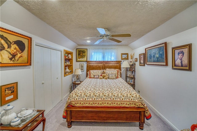 carpeted bedroom featuring a closet, lofted ceiling, a textured ceiling, and ceiling fan