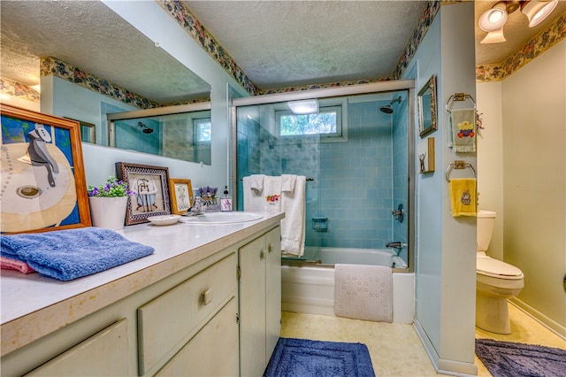 full bathroom featuring shower / bath combination with glass door, vanity, toilet, and a textured ceiling